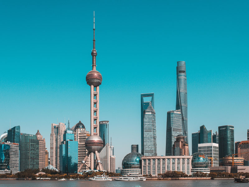 China, Shanghai skyline at dawn, showing the Huangpu river with passing cargo ships and Pudong skyline.